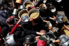 Palestinians gather to receive food aid.