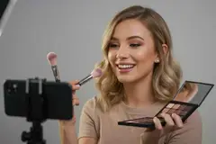 young woman doing makeup video for social media