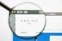 Kering logo under magnifying glass on computer screen.