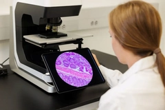 A woman looking at something in a microscope.
