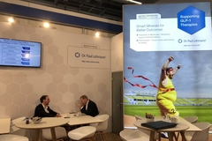 two people sitting in booth with poster on glp-1