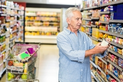 Shopper reading food labels in the supermarket.