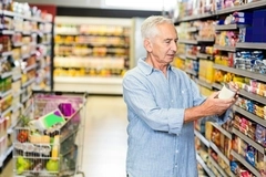 Shopper reading food labels in the supermarket.
