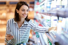 Woman shopping for gut health products in supermarket.