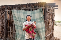 San woman holding her child