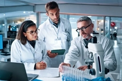 Men and women scientist discuss findings in a laboratory.