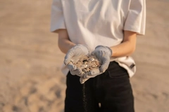woman holding plastic in hands at beach