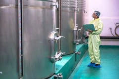 man standing next to fermentation tank man standing next to fermentation tank