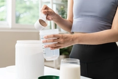 young sporty woman pouring protein powder into a cup