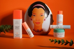 Products of Drunk Elephant in front of a balloon with a woman's face on it.