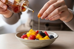 Image Consumer putting swicy sauce on fresh fruit.