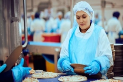 Greencore worker making pizza.