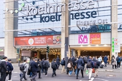 Image A group of people walking in front of a building for trade show