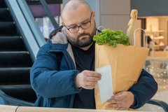Image Man checking supermarket receipt