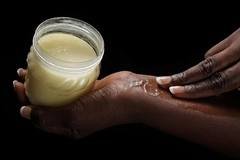 Image Hands putting shea butter on their wrist.