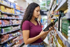 Image woman looking at label in store on olive oil