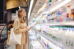 Young woman shops for dairy products in the grocery store.