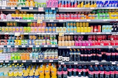Cans and bottles of sodas on the shelf in the supermarket.