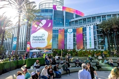 big building with natural products expo west banner and crowd of people outside