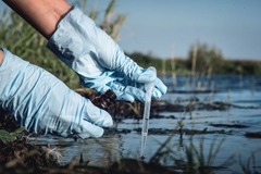 Image person with latex gloves taking a water sample.
