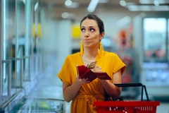 Shopper checking the prices feeling frustrated with her budget