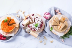 three types of vegan cheese against white background
