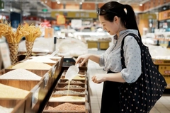 Woman shopping for grains in the grocery store.