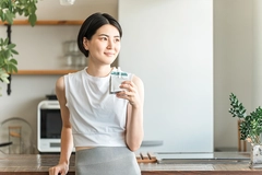 Image young Asian woman in sportswear is shown consuming a nutritional jelly drink