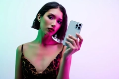 Image Woman in colorful lighting holding cell phone
