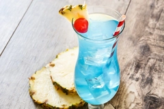 glass of bright blue drink on wooden table