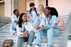 medical students talking while relaxing on staircase at university.