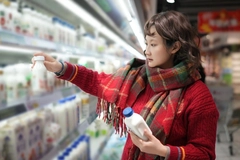 Woman buying dairy products in the grocery store.