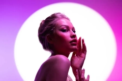 Image Woman in front of a circular light and pink backdrop