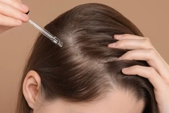 Image Hands putting oil onto their scalp.