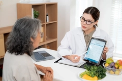 nutritionist showing AI meal plan on tablet to senior patient