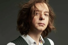 Image A person with long hair wearing a vest