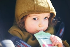 Image child drinking nutrition pouch in car