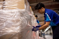 A person in blue gloves working on a large box