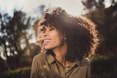A woman with nice hair smiles in the sun. A woman with nice hair smiles in the sun.