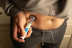Person injecting weight loss medication into their stomach.