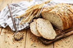 slices of bread next to wheat grains scattered around