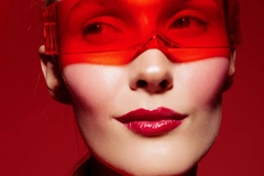 Image Woman with futuristic red glasses against a red backdrop