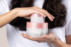 Image A person holding two jars of cream