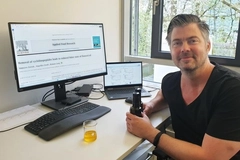 man in black shirt in front of computer
