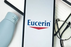 Eucerin written on a phone next to a pair of glasses.