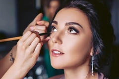 A woman with beautiful hair getting her make up done.