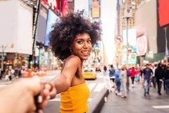A woman in Times Square grabbing someone else's hand.
