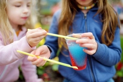 Image Children drinking brightly colored slush ice drink.