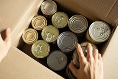 Image A person's hand reaching out to open a box of cans