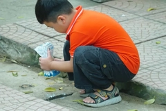 A child crouching down holding carton